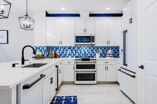 a kitchen with white cabinets and blue tiles at Lakefront Horseshoe Bay Resort Shared Pool Dock in Horseshoe Bay