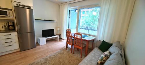a living room with a couch and a table and a kitchen at Kotikaksio Deodar in Lahti