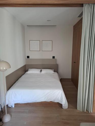 a bedroom with a large bed with white sheets at New 1-bedroom apartment Expo Guadalajara in Guadalajara