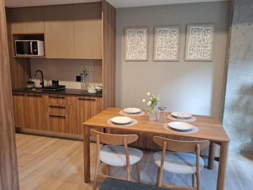 a kitchen with a wooden table and two chairs at New 1-bedroom apartment Expo Guadalajara in Guadalajara