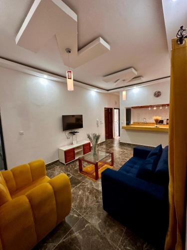 ein Wohnzimmer mit Sofa und Fernseher in der Unterkunft Résidence EDEN in Abidjan