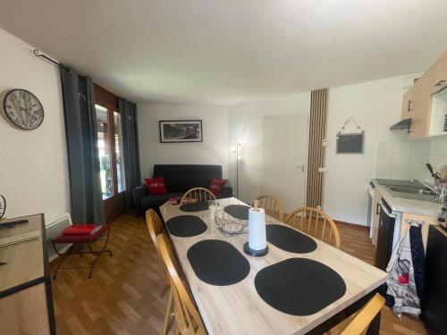 una cucina e un soggiorno con tavolo e sedie di Les 3 balcons du Mont Joly a Les Contamines-Montjoie