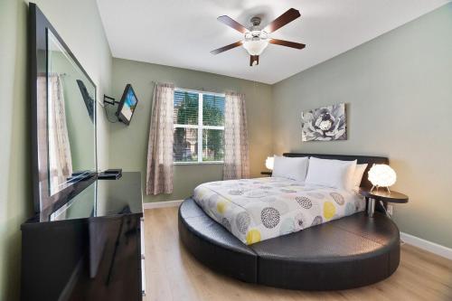 a bedroom with a bed and a ceiling fan at 6 Bed Pool Villa in Luxury Paradise Palms Resort! in Kissimmee