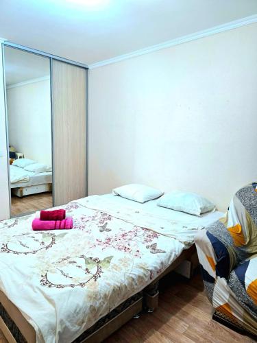a bedroom with a large bed and a mirror at Аэропорт Астана 5 минут 37 in Astana