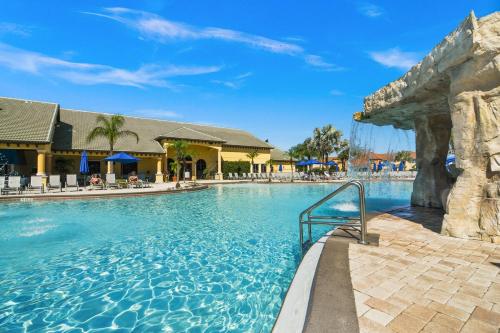 a swimming pool at a resort with a slide at 6 Bed Pool Villa in Luxury Paradise Palms Resort! in Kissimmee