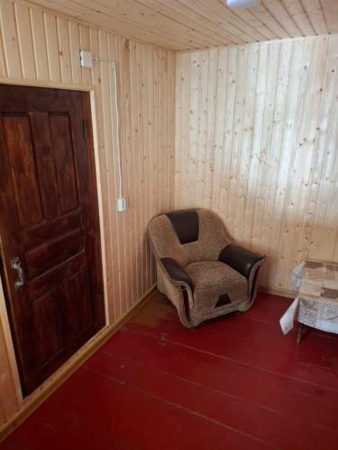an empty room with a chair and a door at საოჯახო სასტუმრო,,ოდა ხიხანთან'' 