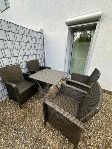 a patio with two chairs and a table and chairs at Große 2 Ferienwohnung Gästehaus NEUBAU Merzig 100 m2 in Merzig