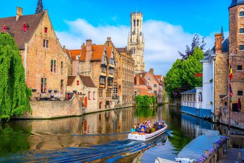 a group of people in a boat on a river in a city at The Green Mile in Aalter