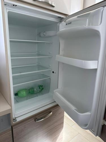 an empty refrigerator with its door open in a kitchen at Große 2 Ferienwohnung Gästehaus NEUBAU Merzig 100 m2 in Merzig