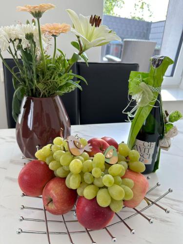 a bunch of grapes on a table with a vase at Große 2 Ferienwohnung Gästehaus NEUBAU Merzig 100 m2 in Merzig