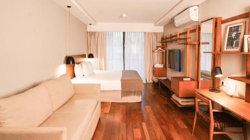 a hotel room with a bed and a couch at AQ Tailored Suites in Buenos Aires