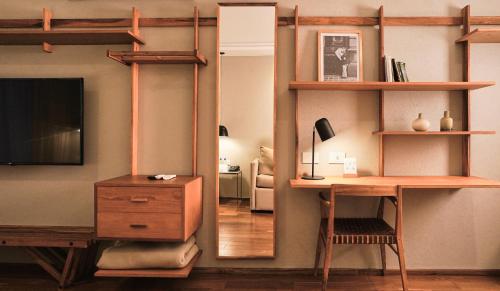a living room with a desk and a mirror at AQ Tailored Suites in Buenos Aires