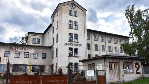 a building with a clock tower on top of it at Loft v továrně Mastných in Semily