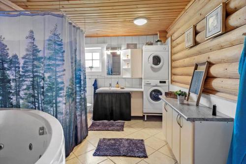 a bathroom with a tub and a sink and a washing machine at M212-Vaeggerlose-Marielyst-Strandpark-127 in Marielyst