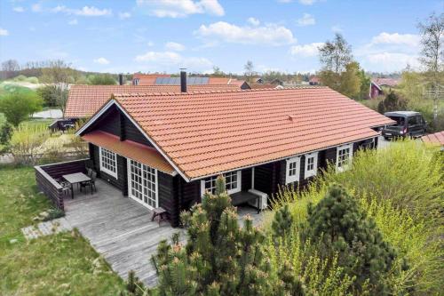a house with an orange roof and a wooden deck at M178-Vaeggerlose-Marielyst-Strandpark-126 in Marielyst