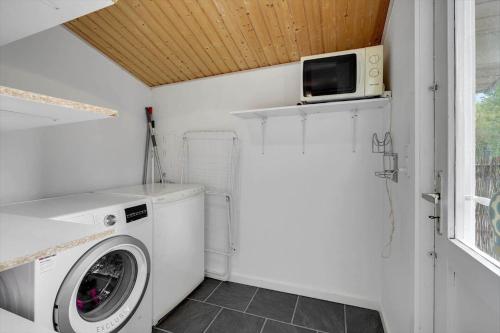 a laundry room with a washing machine and a microwave at S55-Stubbekobing-Birkehegnet-20 in Stubbekøbing