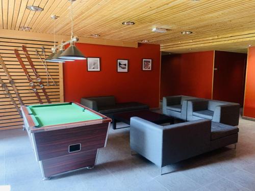 una stanza con tavolo da ping pong e divani di Les 3 balcons du Mont Joly a Les Contamines-Montjoie