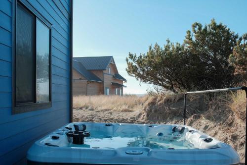 un lavandino del bagno con vista su una casa di Brand-New Beach Retreat Hot Tub Sleeps 13 a Westport