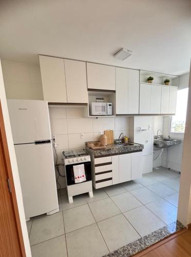 a kitchen with white cabinets and a stove top oven at AP Iilha de Aruba Prox a Avenida Litoranea in São Luís
