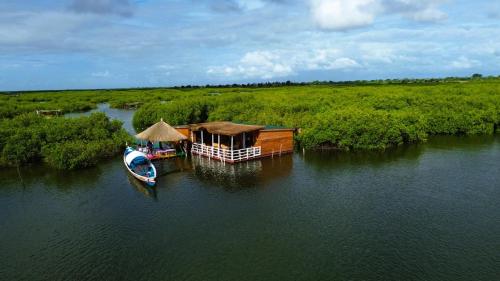 an aerial view of a house and a boat in the water at Maison flottante SWEET MALBALY - chambre double - vue imprenable sur mer- iles du saloum in Fatick