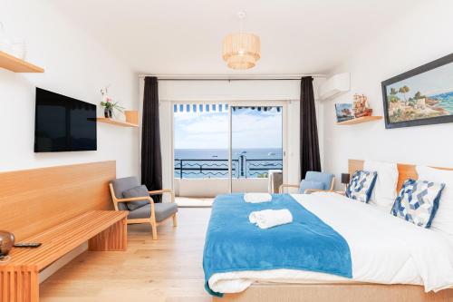 une chambre avec un lit et une vue sur l'océan dans l'établissement Palais des Iles YourHostHelper, à Cannes