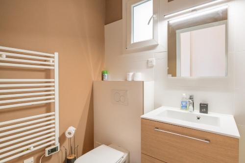 une salle de bain avec toilettes, lavabo et miroir dans l'établissement Palais des Iles YourHostHelper, à Cannes