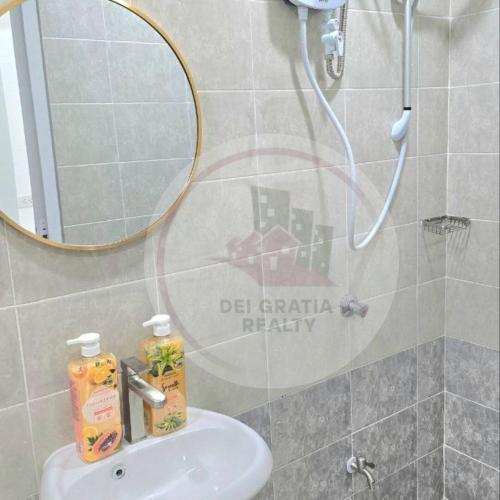 碧瑶Stanford Gf11 Baguio Condo by Dei Gratia的带水槽和带镜子的淋浴的浴室