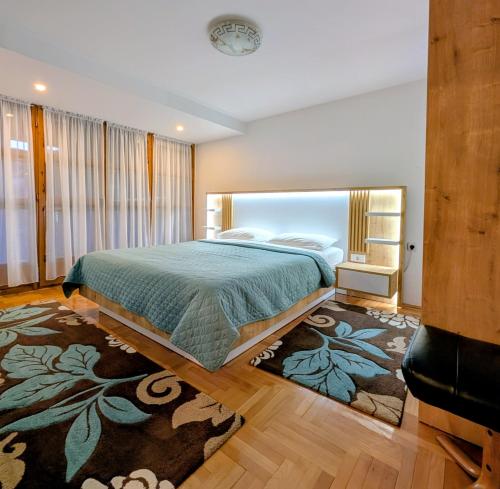 Un dormitorio con una cama grande y una alfombra. en Apartments Šćepanović, en Kolašin