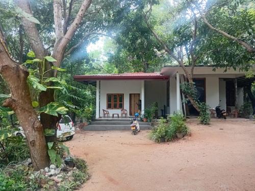 a house with a motorcycle parked in front of it at Sobadahama ( The Nature Rest ) in Diwulankadawala