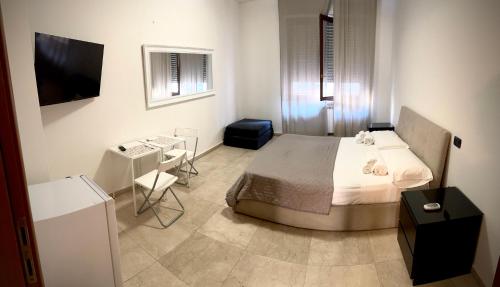 Un dormitorio con una cama, una mesa y un televisor. en B&B 31 mt dal Duomo, en Benevento