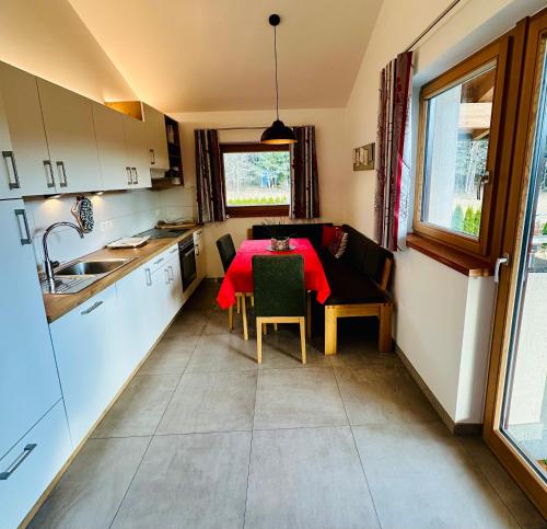 FiumesにあるFrunhaus - Zimmer mit Frühstück, Apartments, Ferienwohnungenのキッチン(テーブル、赤いテーブルクロス付)