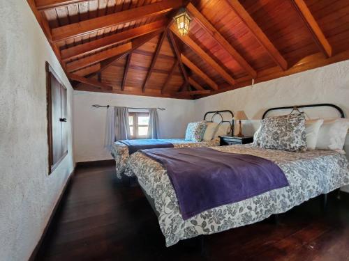 deux lits dans une chambre avec plafonds en bois dans l'établissement El Poleo 2, à El Amparo