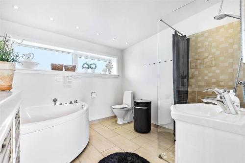 a bathroom with a tub and a sink and a toilet at M167-Vaeggerlose-Savavej-31 in Marielyst
