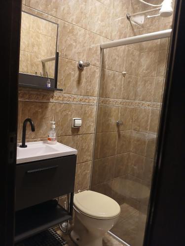 a bathroom with a shower and a toilet and a sink at Cantinho da Familia in São Pedro