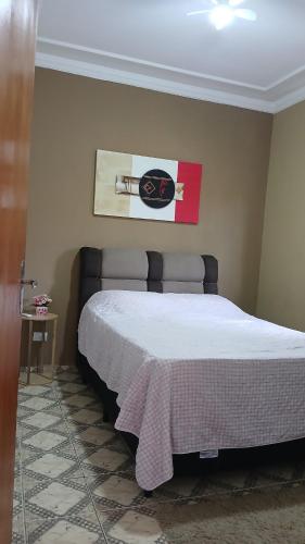 a bedroom with a bed and a picture on the wall at Cantinho da Familia in São Pedro
