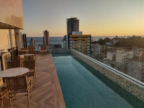 a swimming pool on the roof of a building at Aconchegante apartamento studio na Barra in Salvador