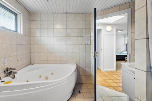 a white bath tub in a bathroom with a window at M323-Vaeggerlose-Skovlystvej-38 in Bøtø By