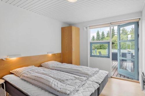 a bedroom with a bed and a large window at M323-Vaeggerlose-Skovlystvej-38 in Bøtø By
