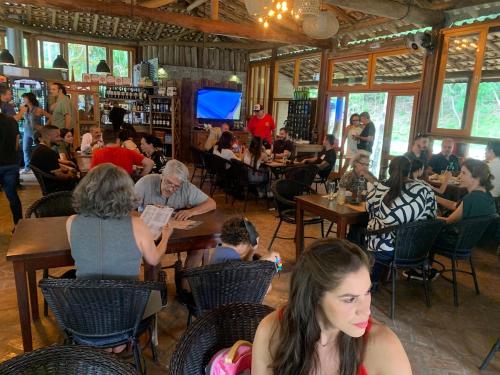 a group of people sitting at tables in a restaurant at Chale cabana 2 linda vista na serra da Cantareira in Caieiras