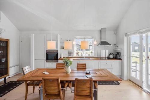 a kitchen and dining room with a wooden table and chairs at L17-Nysted-Marsvinvej-4 in Nysted