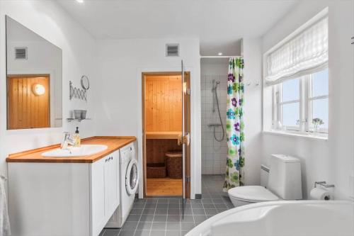 a bathroom with a sink and a washing machine at L17-Nysted-Marsvinvej-4 in Nysted