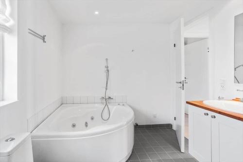 a white bathroom with a tub and a sink at L17-Nysted-Marsvinvej-4 in Nysted
