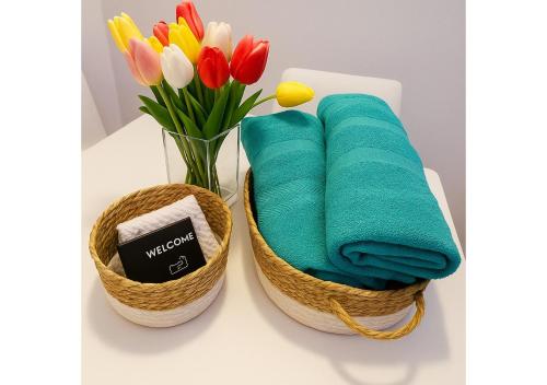 Dos cestas con toallas y flores sobre una mesa. en La Serena del Garda!, en Desenzano del Garda