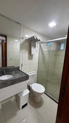 a bathroom with a toilet and a sink and a shower at Blue Sunset com Varanda - Experience in João Pessoa