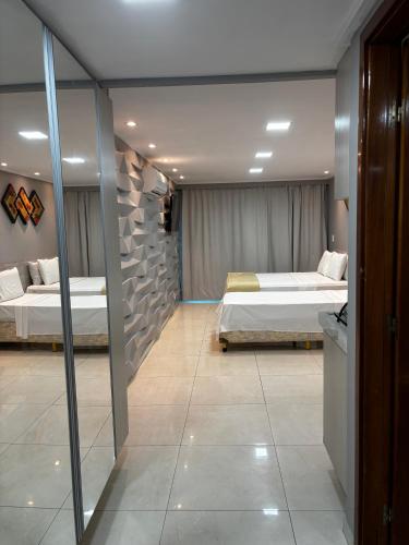 a room with two beds and a hallway with two beds at Blue Sunset com Varanda - Experience in João Pessoa