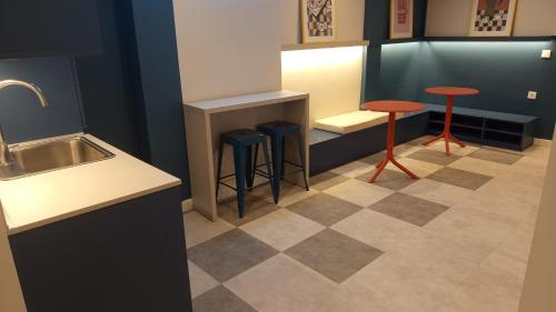 a kitchen with two stools and a counter with a sink at Groma Rooms in Zaragoza