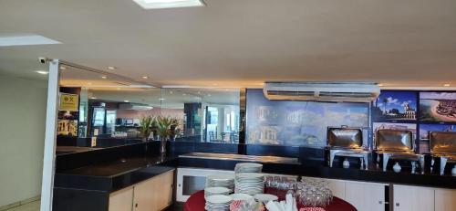 a kitchen with a table with plates on it at Blue Sunset com Varanda - Experience in João Pessoa