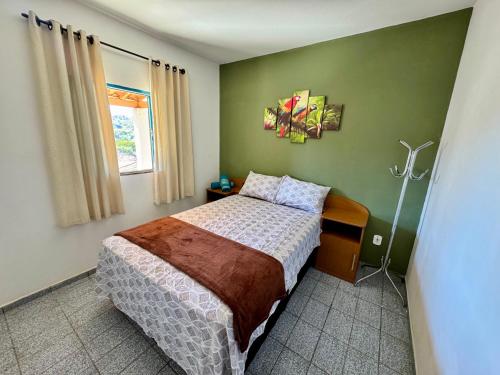 una camera da letto con un letto e una parete verde di Chalé Bela Vista a Socorro
