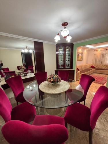 a living room with a table and purple chairs at Casa Confortável 03 Quartos Com Suite, Churrasqueira, Banheira e Garagem in Curitiba