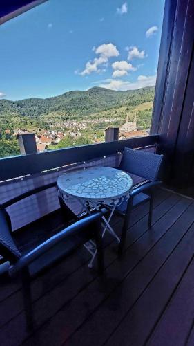 a table and bench on a balcony with a view at Ferienwohnungen Sonnenhalde mit schöner Aussicht in Forbach